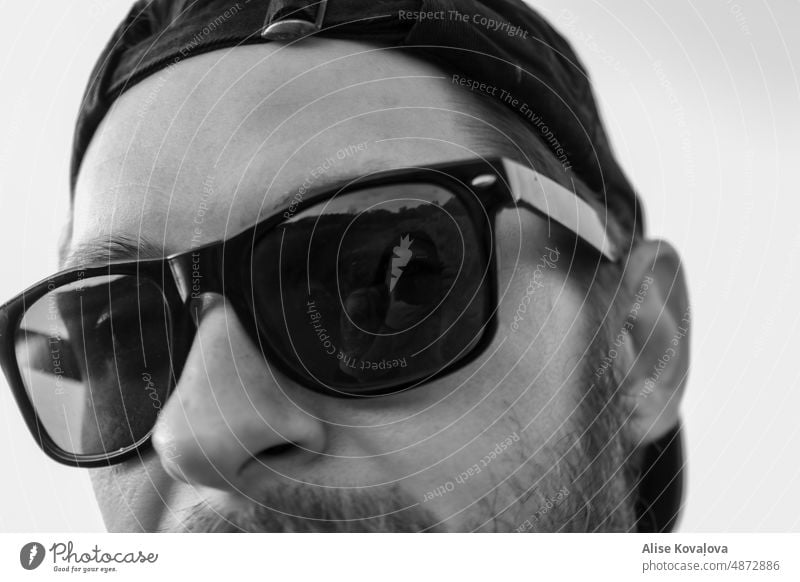 photographer in a reflection sunglasses reflext face male man portrait backwards hat beard black and white see trough dark dark glasses