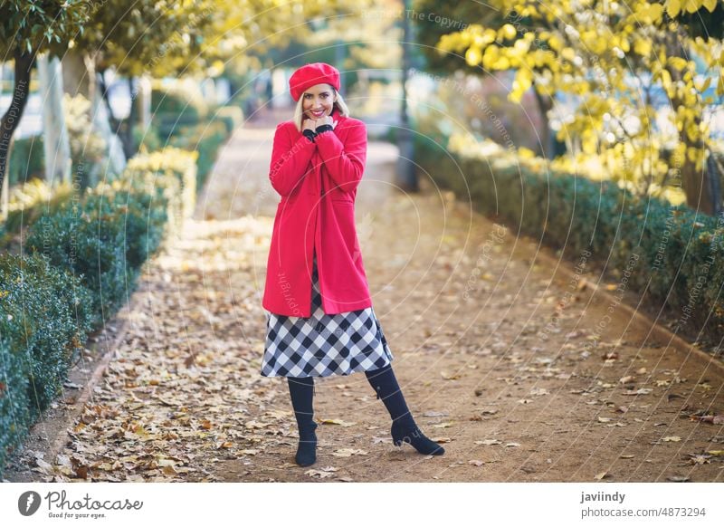 Fashionable woman in autumn park street style fashion feminine design elegant path fall pathway walkway foliage outfit female town red lady wear beret coat