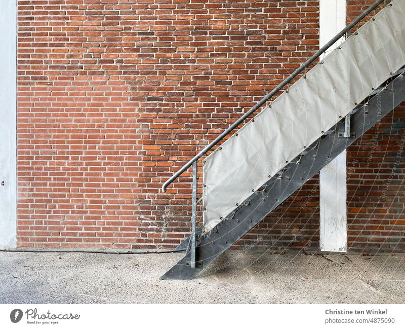 Exterior staircase with privacy tarp in front of a patched clinker wall Stairs External Staircase Metal steps Facade Wall (building) brick wall Brick wall