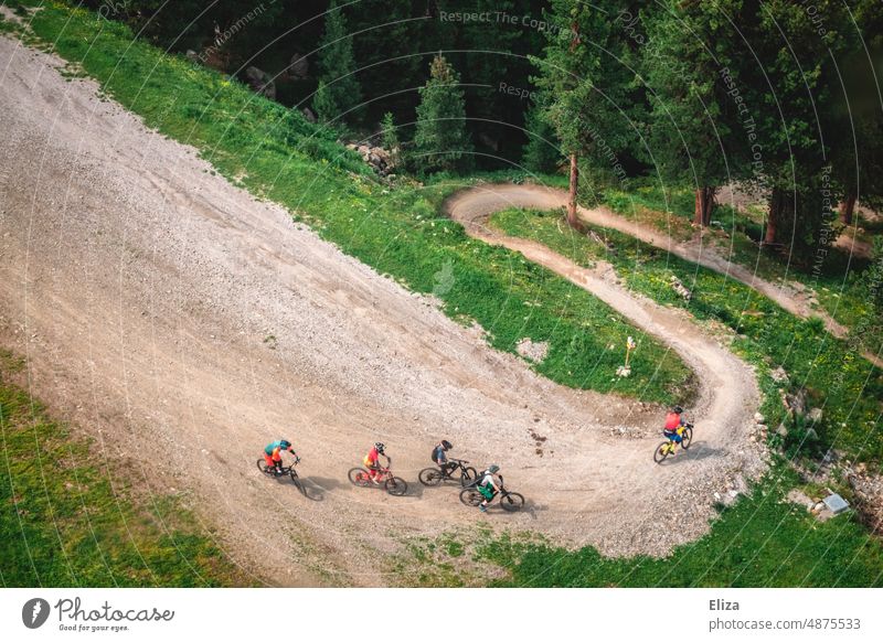 A group of downhill bikers on a downhill track on the mountain cyclist Ski-run curvy Mountain bike Sports cycling Bicycle Cycling Extreme sports Forest Nature