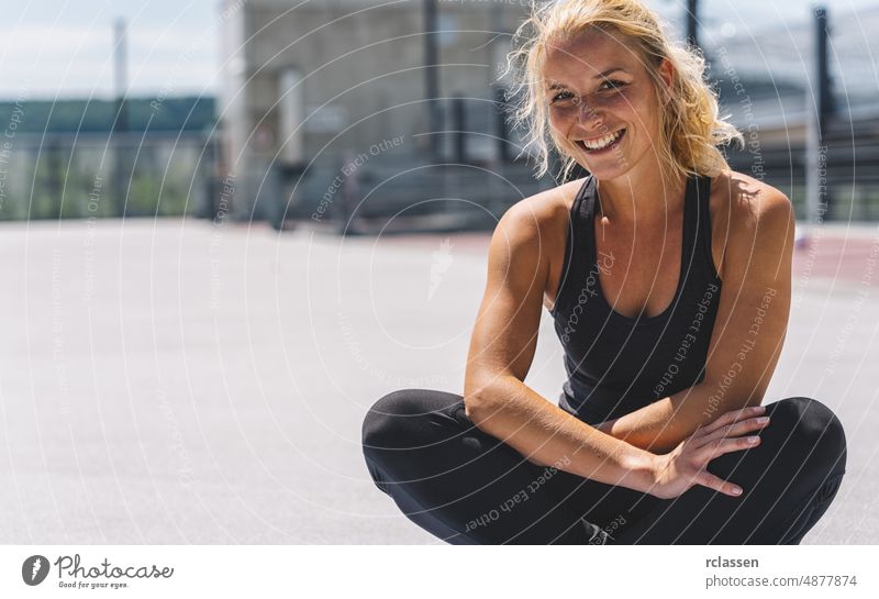Happy attractive young woman in sportswear enjoying Relaxing after training. Cheerful mood, true emotions, healthy lifestyle, smiling fit gym yoga sitting