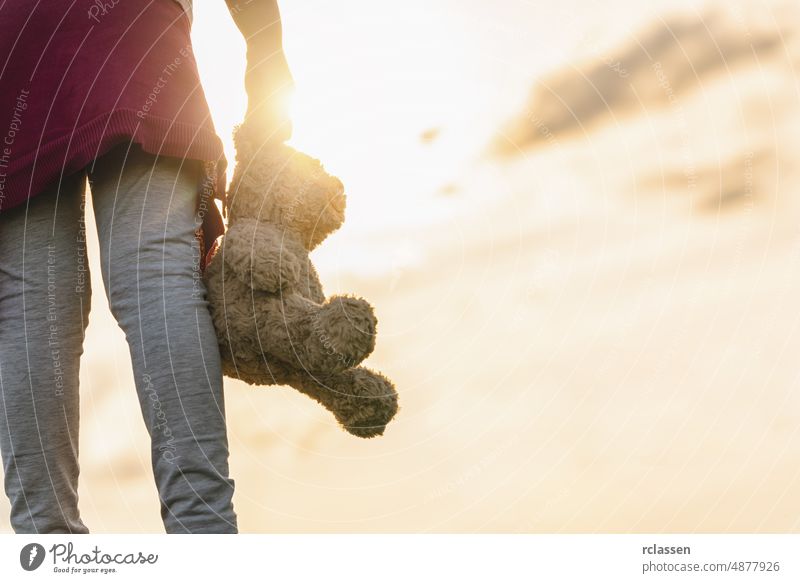 Young Girl standin through a sunset and Carrying a Teddy Bear bear teddy old girl childhood holding lonely adult dream attractive autumn scary dramatic clouds