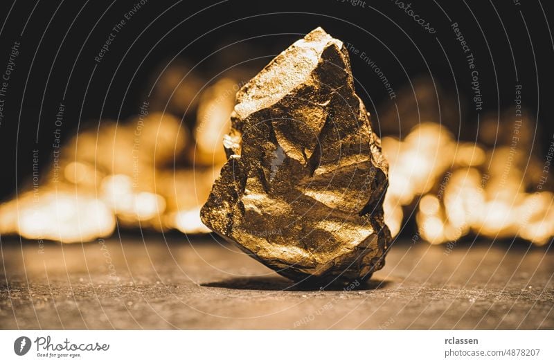 big gold nugget in front of a mound of gold -  finance concept mine ore closeup money mineral jewelry golden wealth action assurance background backing balance