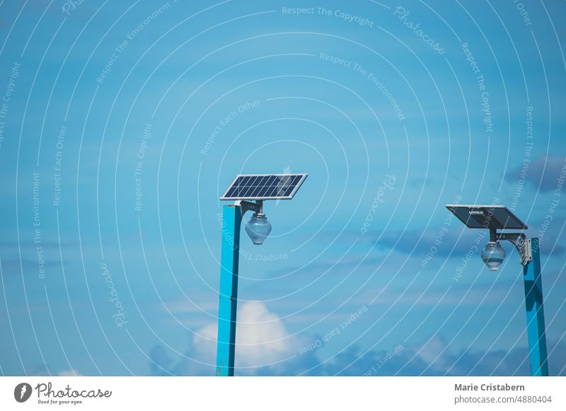Two solar panels powering a lamp post against the blue summer sky solar power clean energy sustainable ecological eco-friendly background copy space minimalism