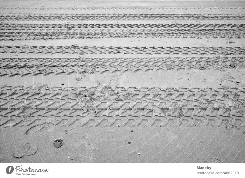 Rough tire tracks in the sand on the beach in Knokke-Heist on the North Sea near Bruges in West Flanders in Belgium, photographed in classic black and white