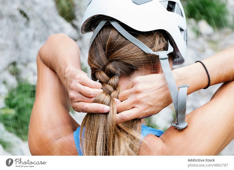 Woman With Safety Helmet Tying Braid Preparing For Hiking Prepare Hiker Closeup Rear View Brown Hair From Behind Climber Adventure Hand Activity Exploration
