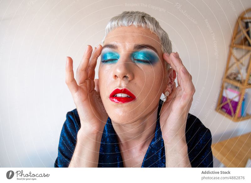 Portrait Of Transgender Man With Makeup Eye Shadow Gay Posing Queer Fashion Individuality LGBTQI Closeup Pride Studio Shot Feminine Red Lipstick Background