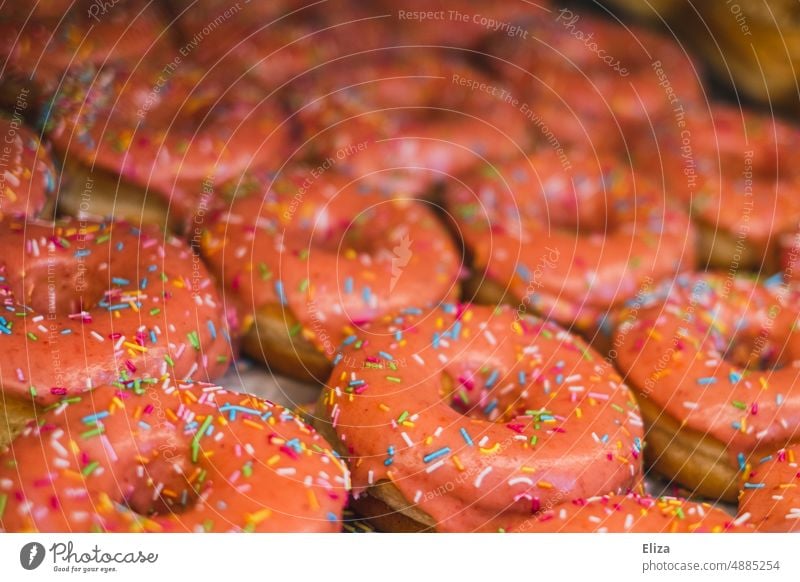 Many pink donuts with colorful sprinkles Pink variegated biscuits Granules cute Sugar Bakery Bakery shop sugar-sweet Delicious Icing Dessert