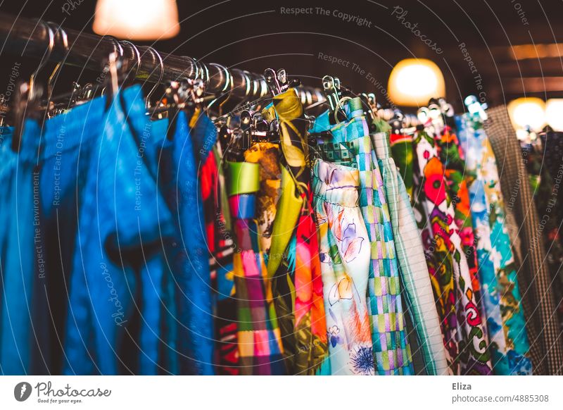 Colorful clothes on a clothes rail in a second hand store or flea market Sustainability garments variegated Flea market business Second-hand shop Fashion