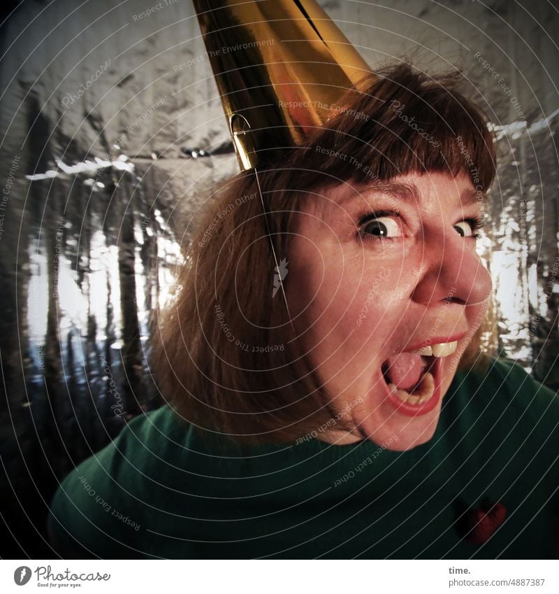 Woman with party hat in celebration mood portrait Face Long-haired Red-haired Looking action Half-profile silver tarpaulin mouth opened Crazy New Year's Eve