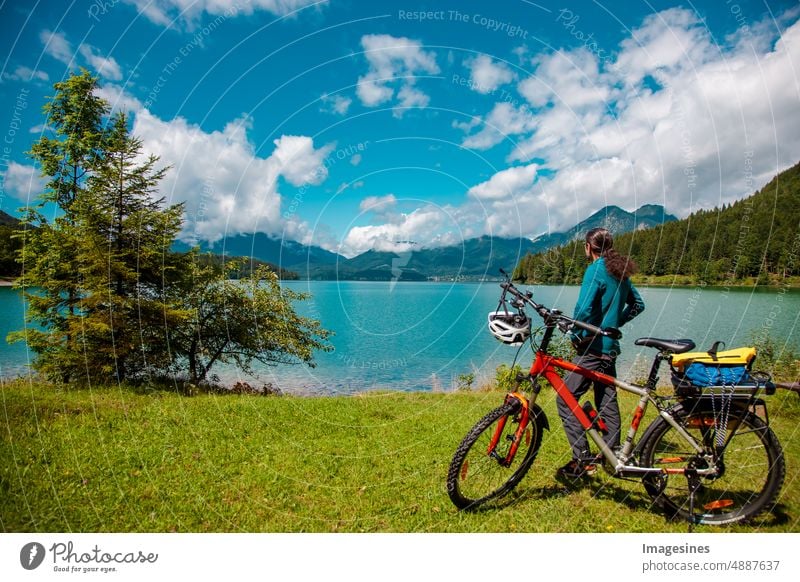 Cycling, back view of biker in green idyllic landscape. Landscape Walchensee in Bavaria. Karwendel mountains in Germany, Europe Bavarian foothills of the Alps