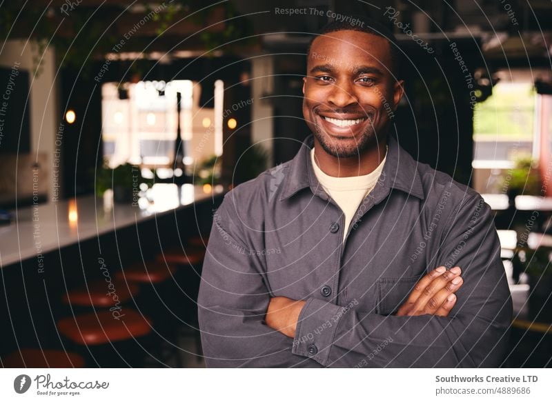 Smiling Young Black Male Standing In Office Looking At Camera With Arms Crossed smiling confident black male professional Coffee Shop african american
