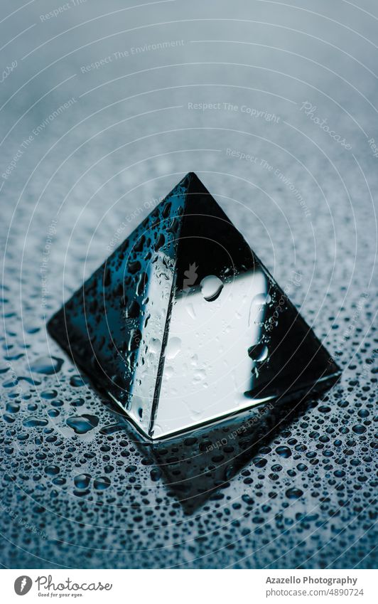 Shiny geometric object with drops of water. Wet trasparent pyramid close up view. glass minimalism still life raindrop droplet wet freshness h2o gradient