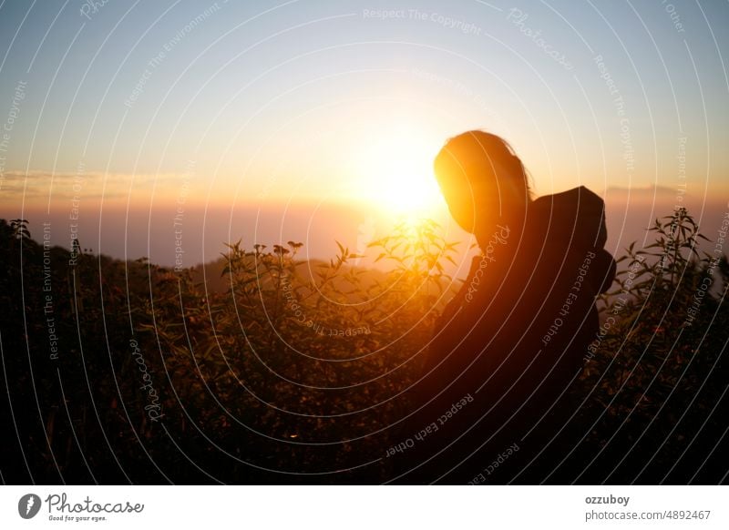 Young woman admiring the sunset over the mountain hill person outdoor sunrise nature back sunlight lifestyle freedom female girl hiking morning rear view young