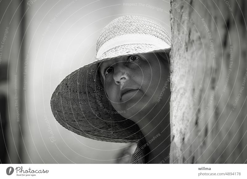 Mature woman with straw hat looks up questioningly Woman portrait Straw hat vacation visit Sightseeing asking Midlife crisis Meditative Observe Curiosity