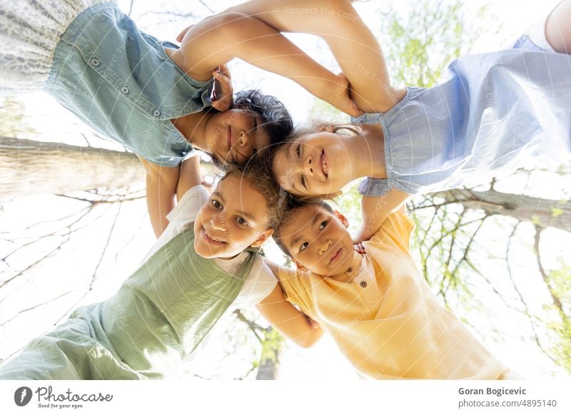 Group of asian and caucasian happy kids huddling, looking down at camera and smiling low angle activity boy bright casual cheerful child childhood children cute