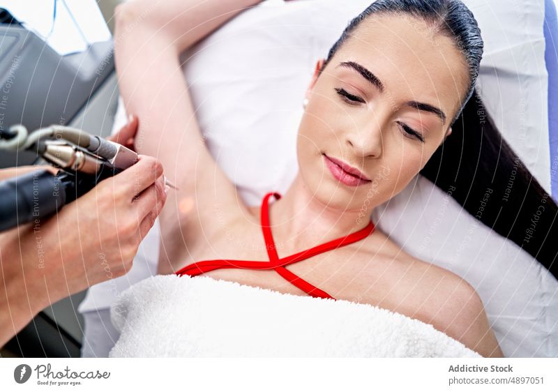Esthetician epilating armpit of woman beautician customer epilation laser procedure clinic aesthetic remove hair women client therapy service salon apparatus