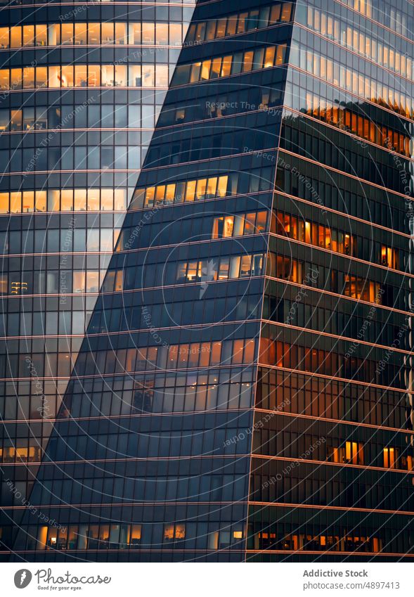 Geometric building with mirrored windows facade skyscraper architecture multistory infrastructure futuristic glass wall construction dense urban office