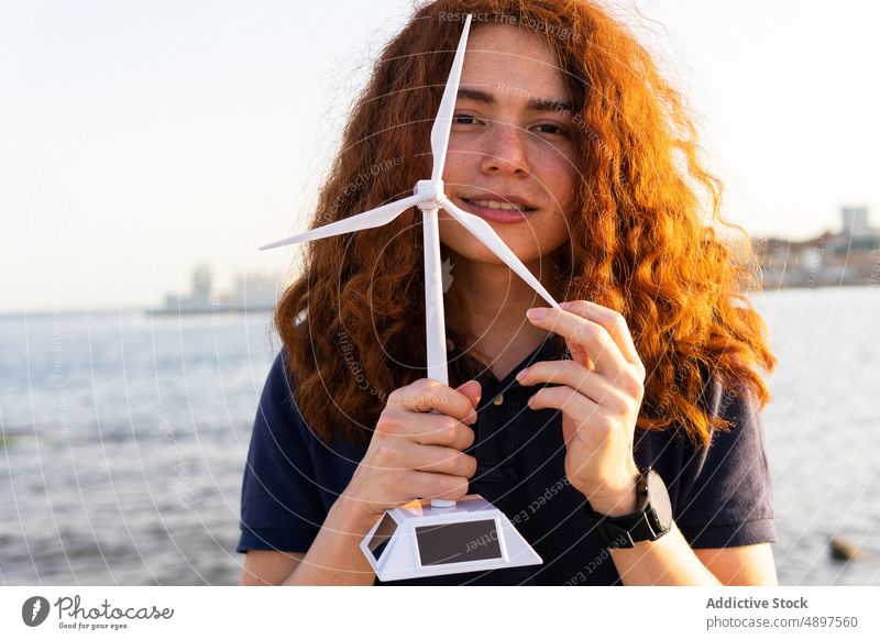 Woman holding up Windmill Model Part Of Renewable Sea Retaining Wall Ecology City Sky Recyclable Miniature Electricity Technology Cropped Finger Resource