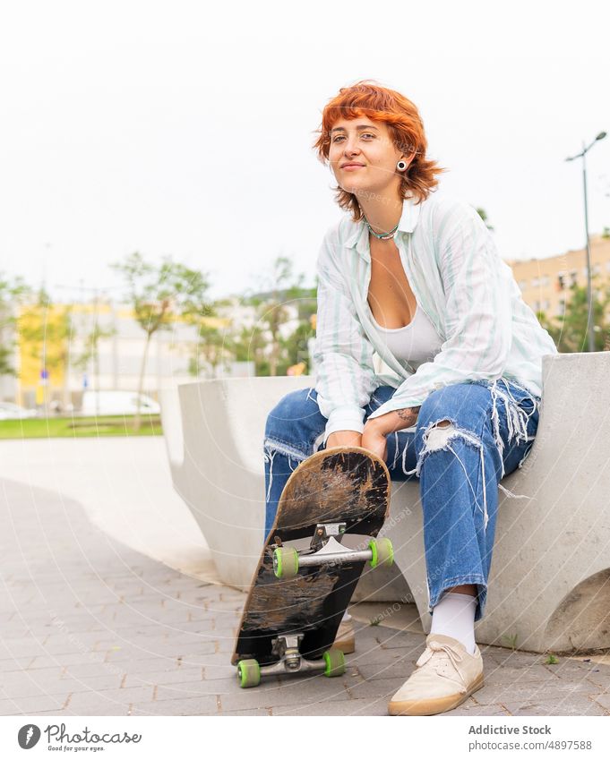 Woman with skateboard on street woman skate park skateboarder hobby sporty pastime leisure urban content activity casual jeans attractive summertime wear outfit