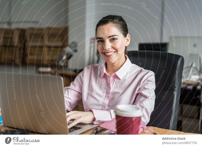 Joyful woman with coffee typing on laptop work browsing office workplace project business businesswoman using formal hot drink positive female takeaway beverage