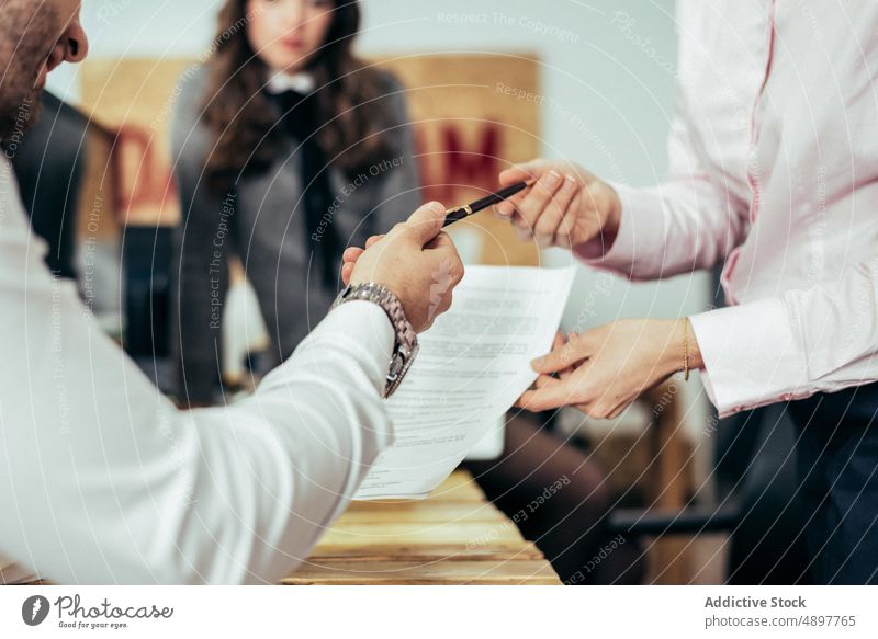 Unrecognizable man taking pen from coworker colleague document paperwork office teamwork cooperate business stationery employee formal occupation professional