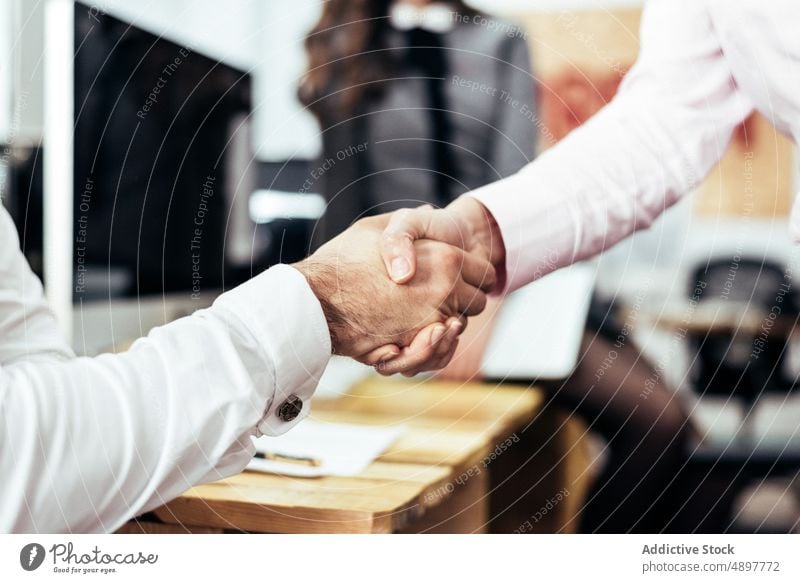Unrecognizable coworkers shaking hands in office colleague deal handshake agree workplace business partner formal career table job occupation cooperate