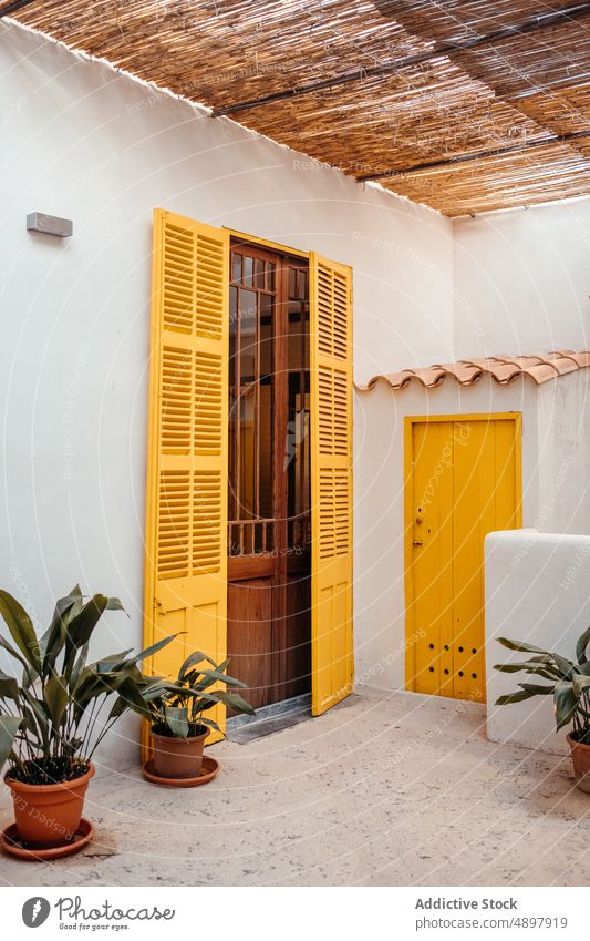 Facade of typical white house with yellow doors in Mallorca exterior yard residential facade architecture plant cottage entrance dwell potted estate sunlight