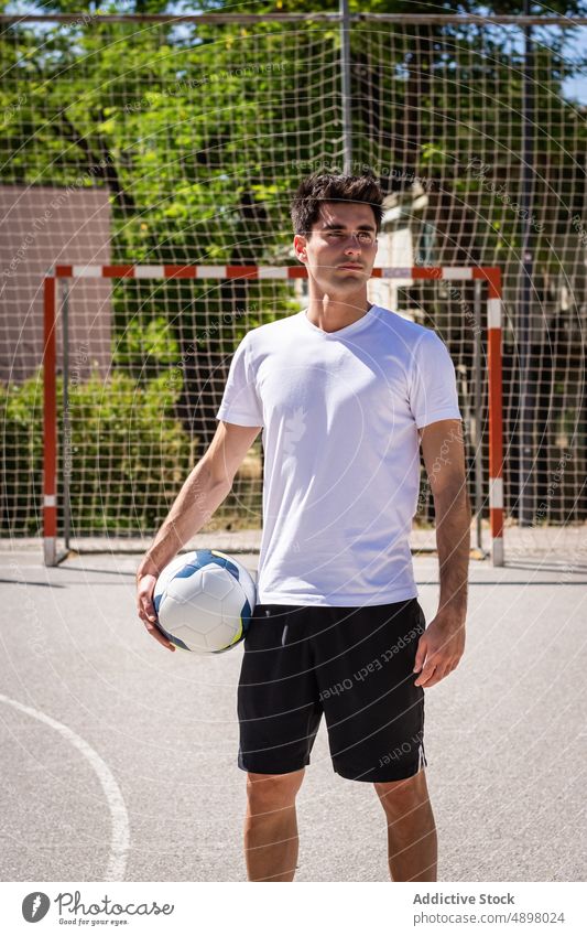Young Football Player Looking Away Male Serious Soccer Ball Practicing Athlete Playing Sport Fitness Hobby Court Goal Competition net Handsome Sportsman Active