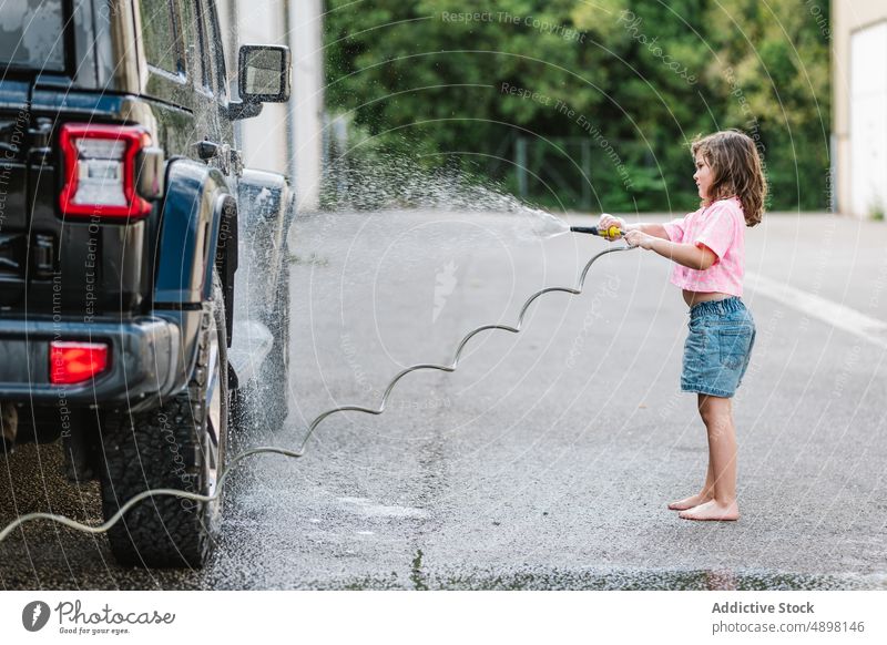 Cute girl With hose while washing the car Hose Spray Wash Motion Clean Looking Water Wet Care Lifestyle Dirty Casual Little Innocent Outside Self Service