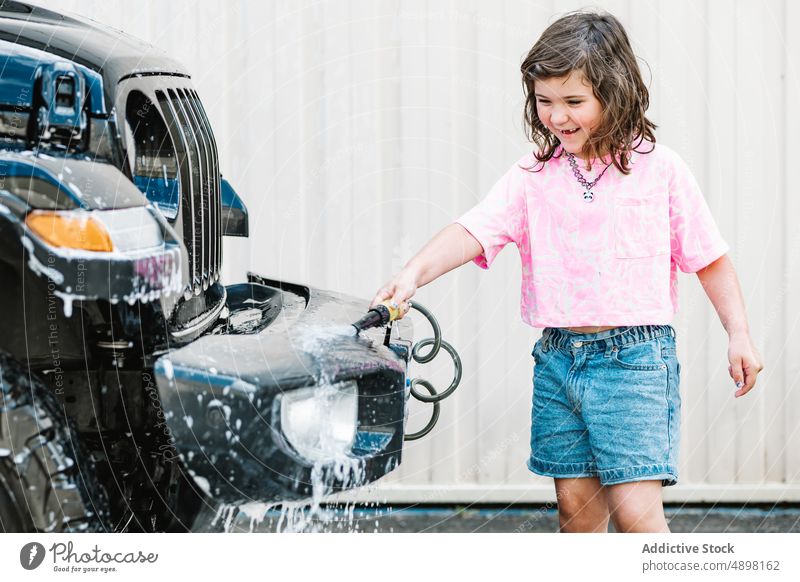 Girl In Casuals Washing Car With Hose On Road Spray happy Motion Clean Water Cute Wet Care Transportation Lifestyle Dirty Little Innocent Outside Self Service