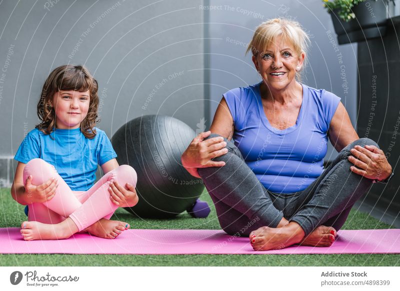 Smiling Elderly Woman With Girl Doing Yoga On Mat Exercise Training Relax Smile Family Flexibility Meditate Teaching Fit Healthy Learning Child Senior Active