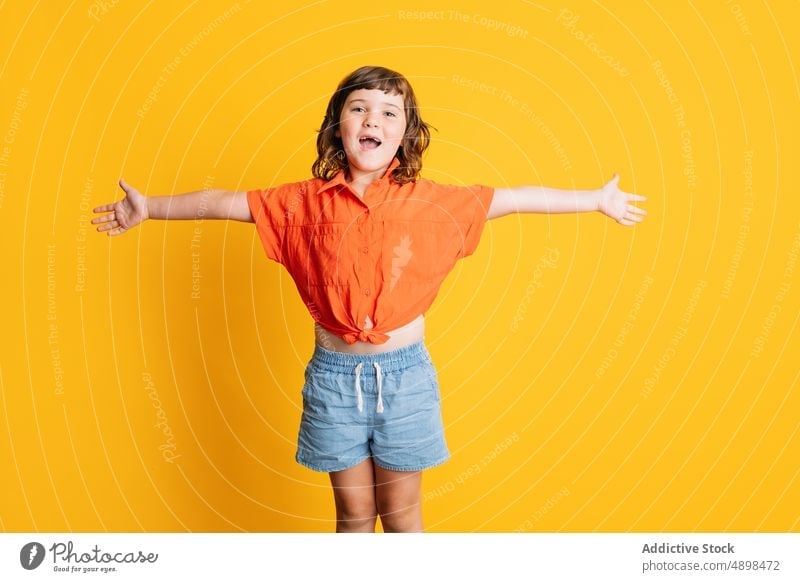 Cheerful girl with outstretched arms smile happy style colorful bright child casual portrait delight gesture childhood little glad vibrant arms open joy sincere