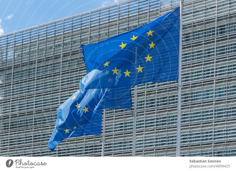 Three EU Flags waving in front of the European Union Commission building in Brussels, Belgium eu symbol politics council euro international legislation