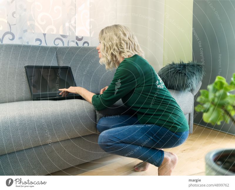A woman on video - chat Woman laptop Computer blonde hair Blonde Sofa Video call Face Feminine Adults buissnes Kneeling Young woman Face of a woman