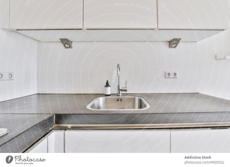 Stainless sink with faucet in kitchen tap counter hygiene modern appliance apartment style bottle soap tile flat metal sanitary residential washbasin