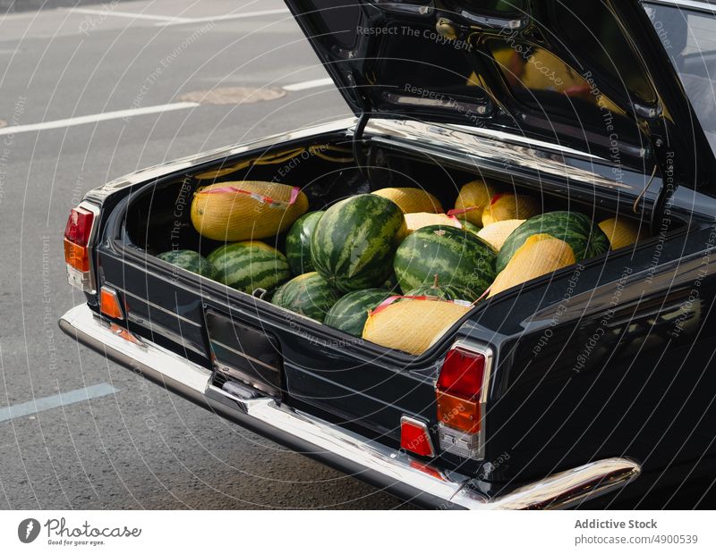 Retro car with melons and watermelons trunk sell commerce road open parked retro street asphalt vintage vehicle transport sale auto automobile old timer local