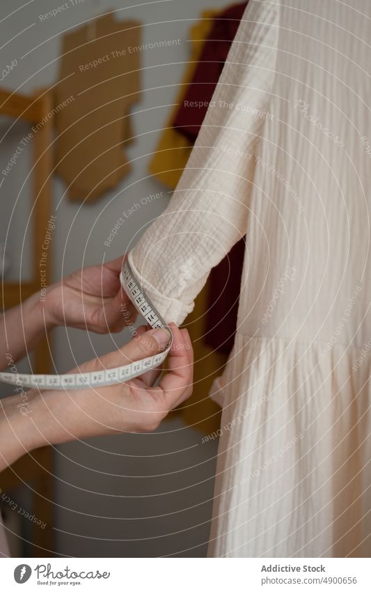 Seamstress measuring sleeve of white dress seamstress measure tape studio handmade small business occupation professional atelier craft designer tailor