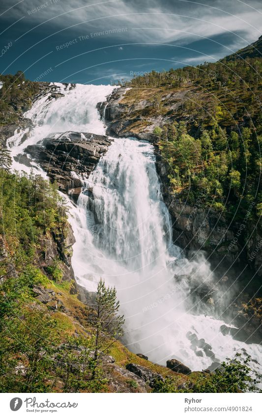 Kinsarvik, Hordaland, Norway. Waterfall Nyastolfossen In Hardangervidda Mountain Plateau. Nyastolsfossen in Spring Sunny Day. Height Of 115 m. Norwegian Landmark And Popular Destination.