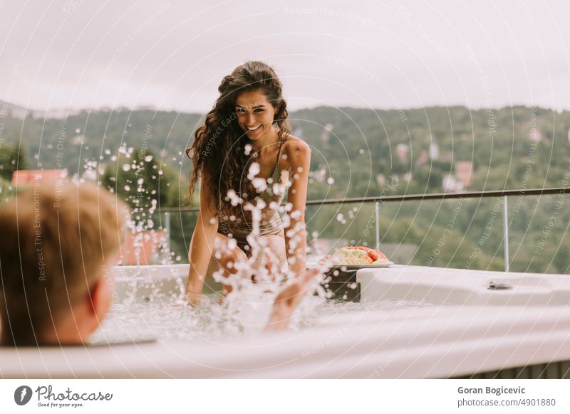 Young couple enjoying in outdoor hot tub on vacation love woman young happy summer beautiful holidays bubble romantic wellbeing wellness resort bath leisure spa