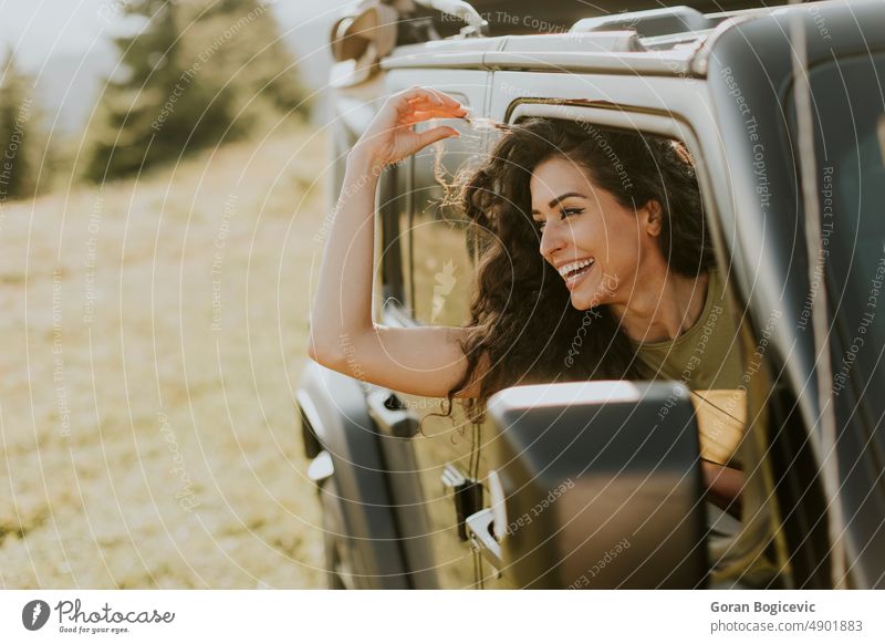 Young woman enjoying freedom in terrain vehicle on a sunny day happy smile beautiful road female drive young car happiness fun auto trip journey transport