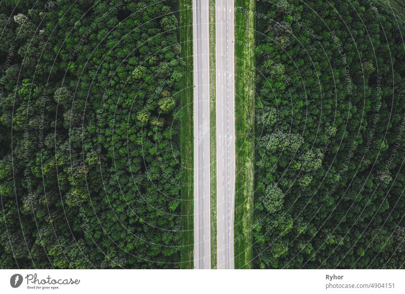 Aerial View Of Highway Road Through Green Forest Landscape In Summer. Top View Flat View Of Highway Motorway Freeway From High Attitude. Trip And Travel Concept