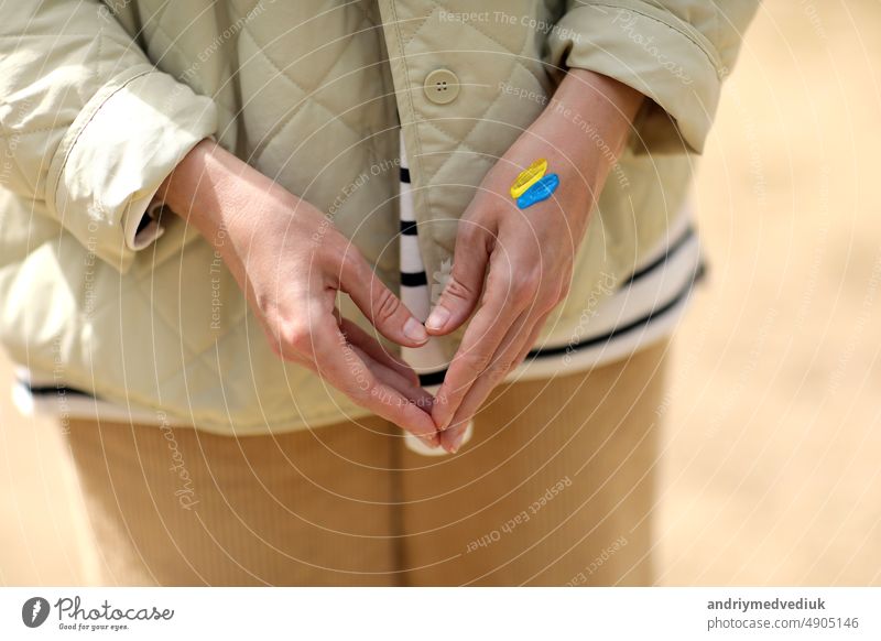 Stop War. Peace in Ukraine. woman with picture of flag of ukraine on hand. Antiwar support concept. High quality photo. conflict pray pray for ukraine europe