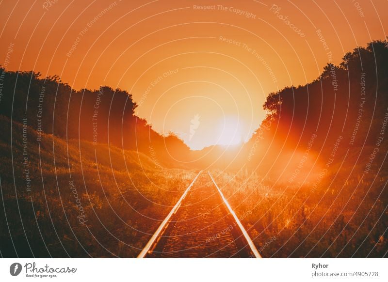 Railway In Dramatic Sunset Backlight. Scenic View Of Railway Going Straight Away In Sunlight. Transportation And Travel Railroad Concept backlight backlit