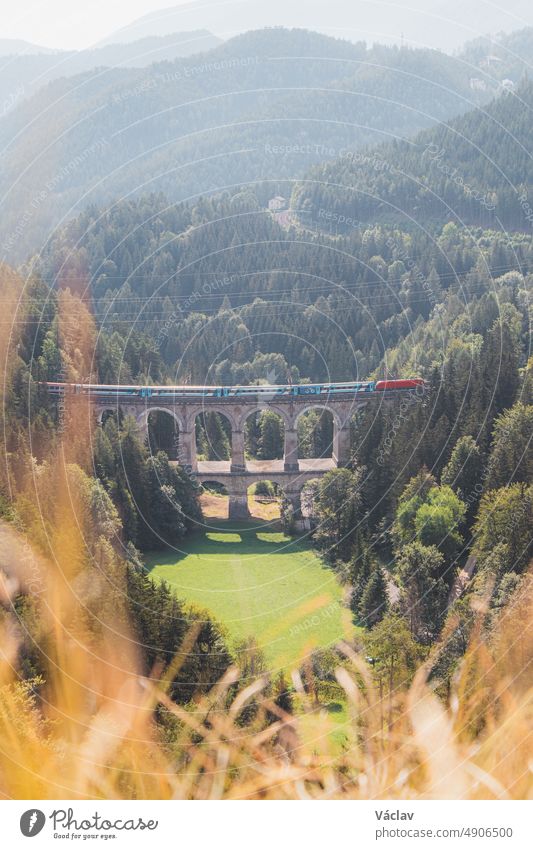 View of the Kalte Rinne railway viaduct and a passing train in Semmering, Rax-Schneeberg Group, Styria, Austria semmering semmeringbahn raxalpe kalte rinne