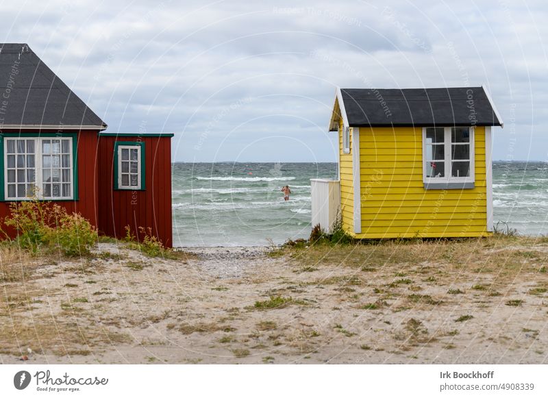 colorful bath houses with bather in the background in the waves Sunlight Copy Space top Exterior shot Colour photo beach position Aerø Beach hut