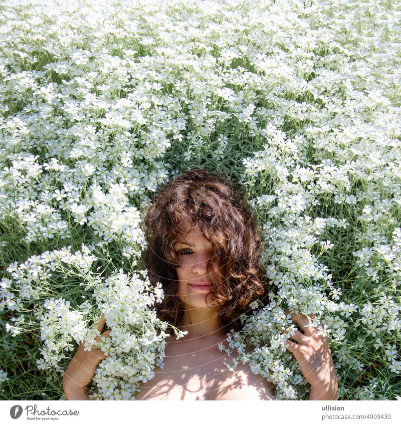 Portrait of a beautiful young sensual brunette woman between many white flower blossoms enjoying her life and nature magic attractive april lifestyle sexy