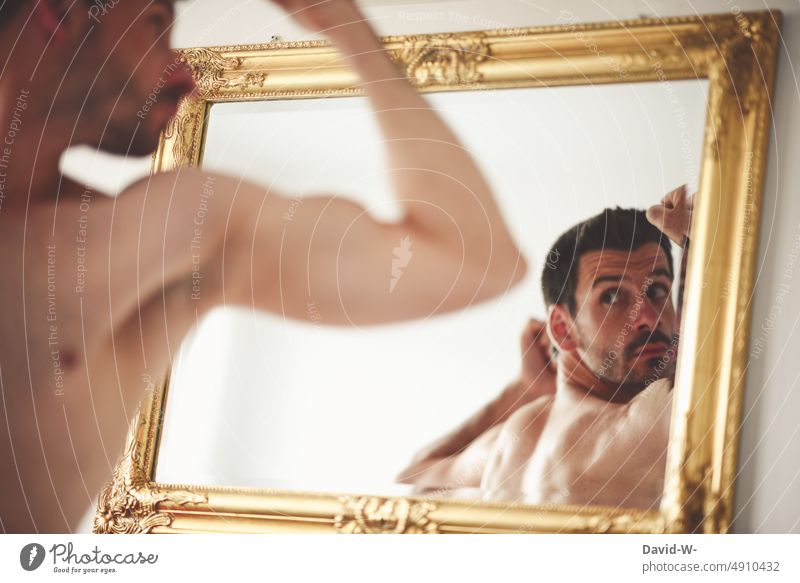 Man looks at himself in mirror Mirror Mirror image self-critical pose look at muscle Self-confidence Observe Looking Body Conceited tighten sexy