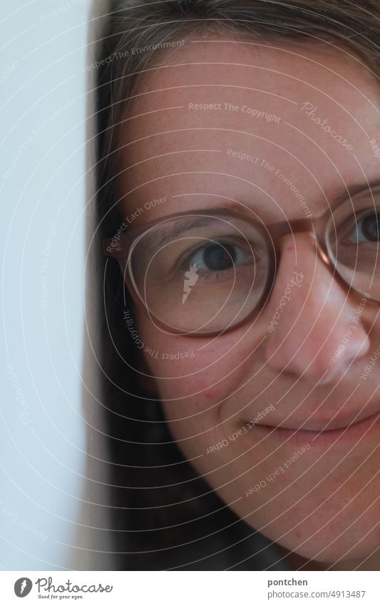 Face of smiling woman with glasses leaning against wall Woman Eyeglasses Wall (barrier) Lean Adults portrait contented Partially visible at home interior