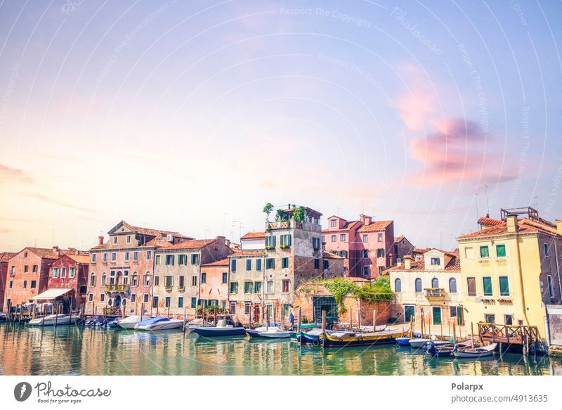 Boats outside old residents in Venice Italy harbor windows brick historical ancient romantic residential sightseeing village exterior nobody sunset bright